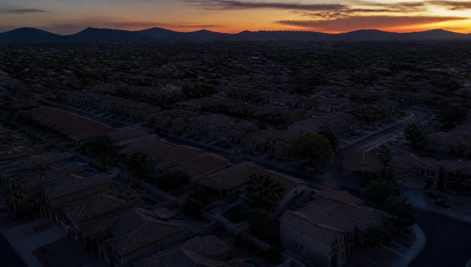 Aerial view of a Phoenix desert neighborhood at dusk with mountains on the horizon
